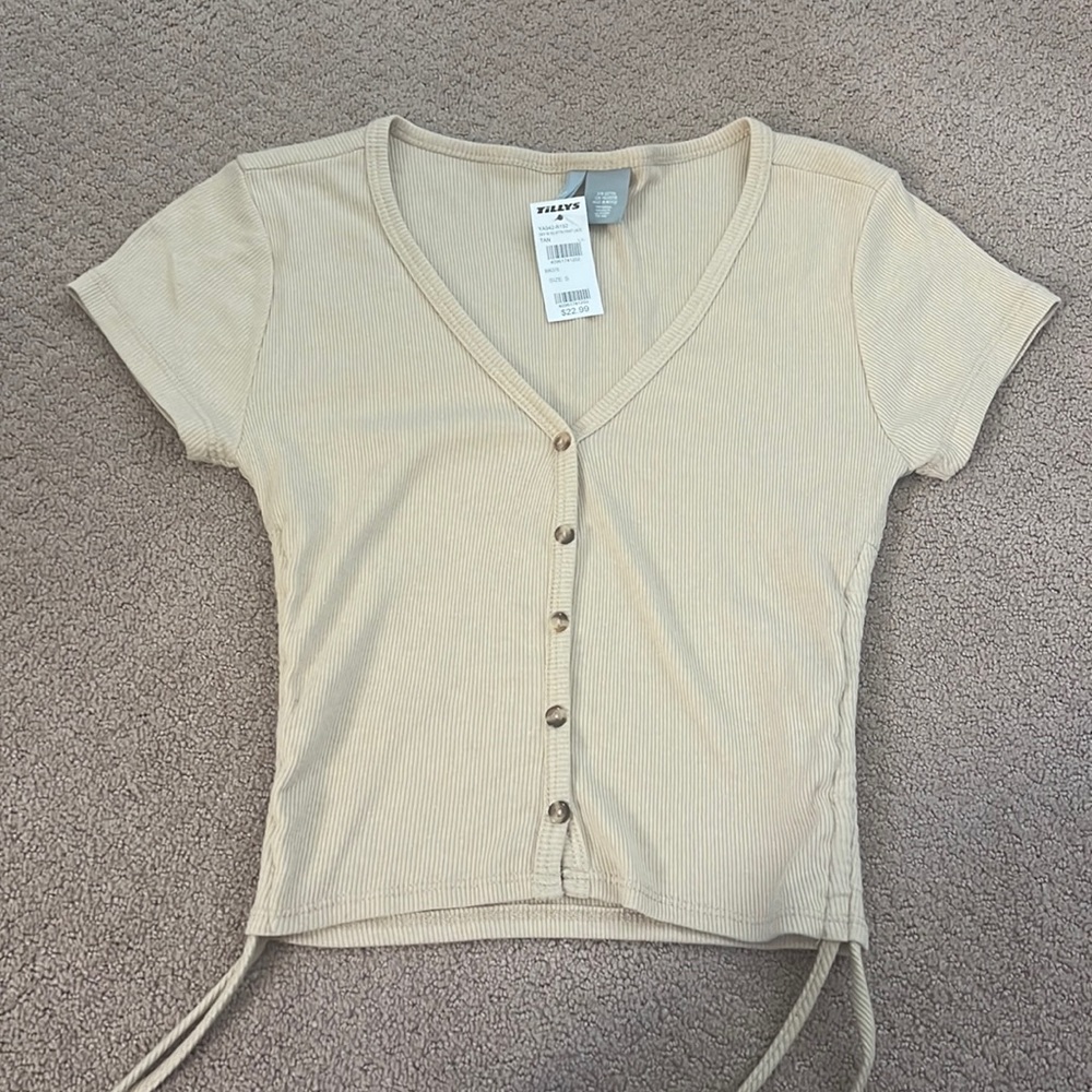 Tan shirt with Sanchez on the side and buttons on the front sky and sparrow